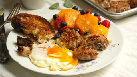 maple sage breakfast sausage on plate with eggs toast and fresh fruit breakfast plate