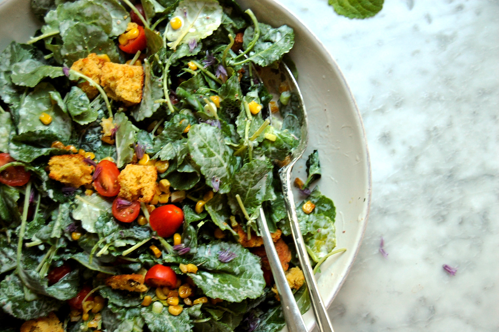 kale salad with corn and tomatoes and croutons