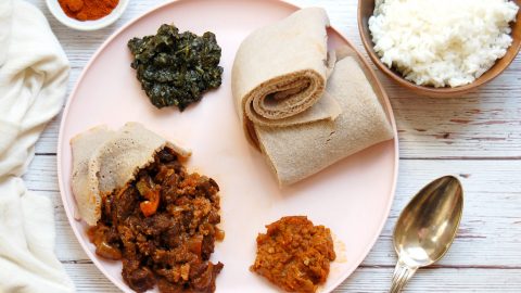 platter of ethiopian beef tibs with injera spinach and lentils