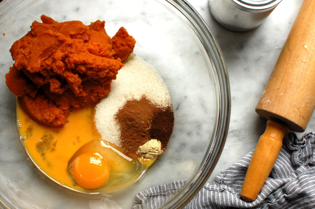 Stirring Libby's pumpkin pie filling with pumpkin, eggs, and spices for creamy custard