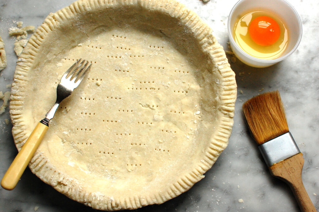 Preparing pre-baked pie crust in pan to prevent soggy crust for Libby's pumpkin pie