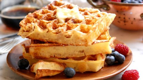 stack of waffles with blueberries and syrup