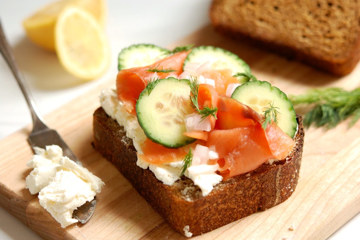 cured cured salmon cucumber smorrebrod toast on wooden board with garnishes cucumber smorrebrod toast on wooden board with garmishes