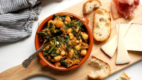 spinach and chickpea Spanish tapas in bowl with bread and cheese
