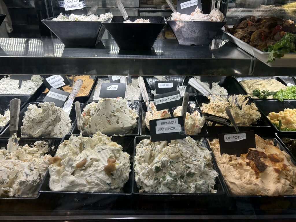 display case of many types of cream cheese options at a NY bagel shop