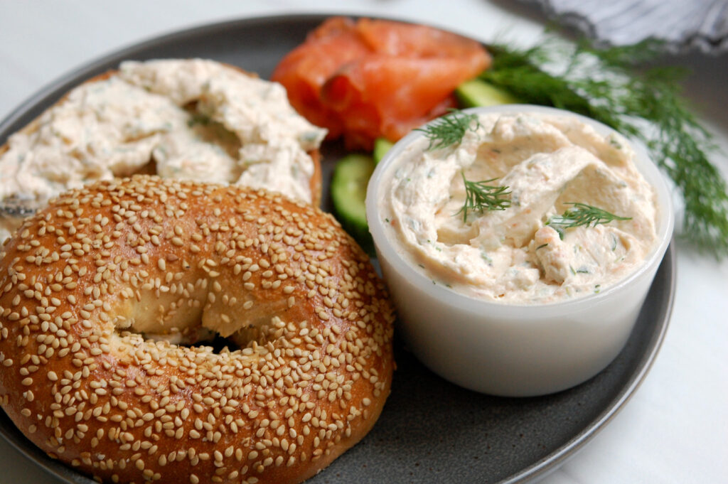 finished bowl of smoked salmon cream cheese spread with bagel and herbs