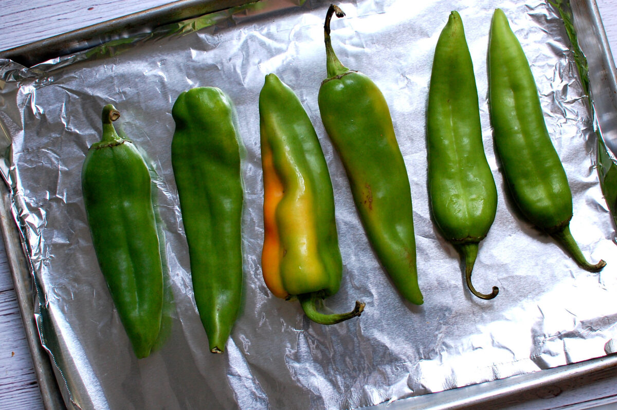 hatch green chile peppers on foil-lined sheet pan, ready to broil