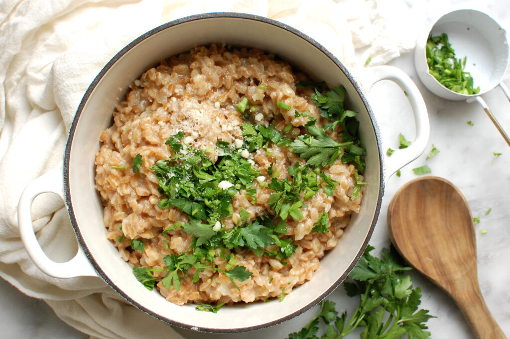 creamy parmesan farro recipe in pot with parsley and broth
