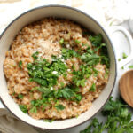 creamy parmesan farro recipe in pot with parsley and broth