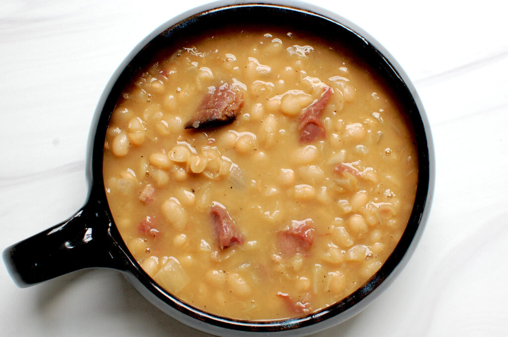 bowl of finished Senate bean and ham soup with chunks of ham after cooking for 3 hours
