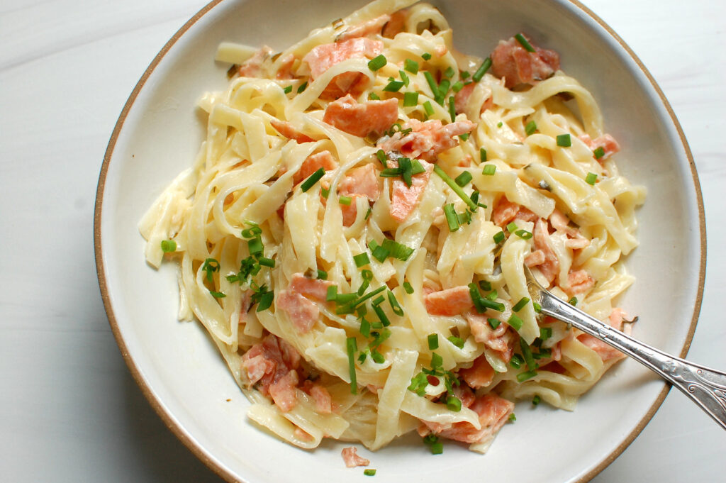 creamy smoked salmon pasta with lemon cream sauce and fresh chives in pasta bowl ready to serve for dinner