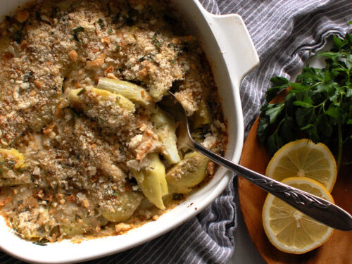 Italian artichoke casserole in a white baking dish with golden breadcrumb topping
