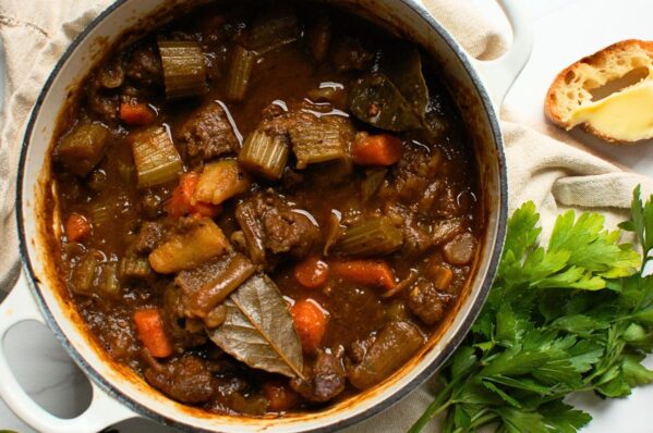 Finished ground venison stew in a bowl with potatoes, carrots, and fresh herbs