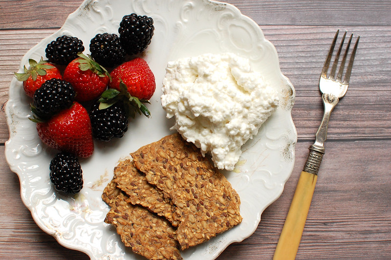 high protein breakfast cottage cheese on plate with fruit and seed crackers