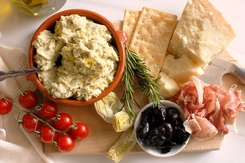 Italian artichoke spread served with crackers, bread, and charcuterie