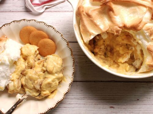 Old fashioned Southern banana pudding with golden meringue topping, baked from scratch in a white casserole dish.