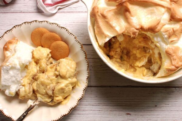Old fashioned Southern banana pudding with golden meringue topping, baked from scratch in a white casserole dish.