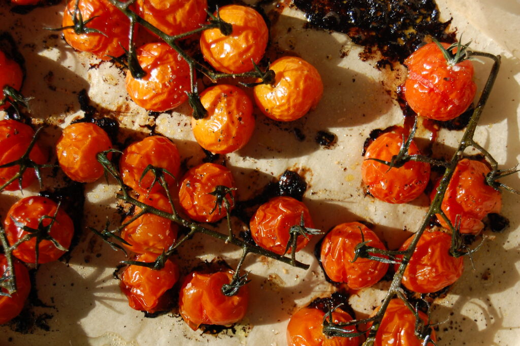 sheet pan of roasted cherry tomatoes on the vine for a simple roasted summer vegetable dish