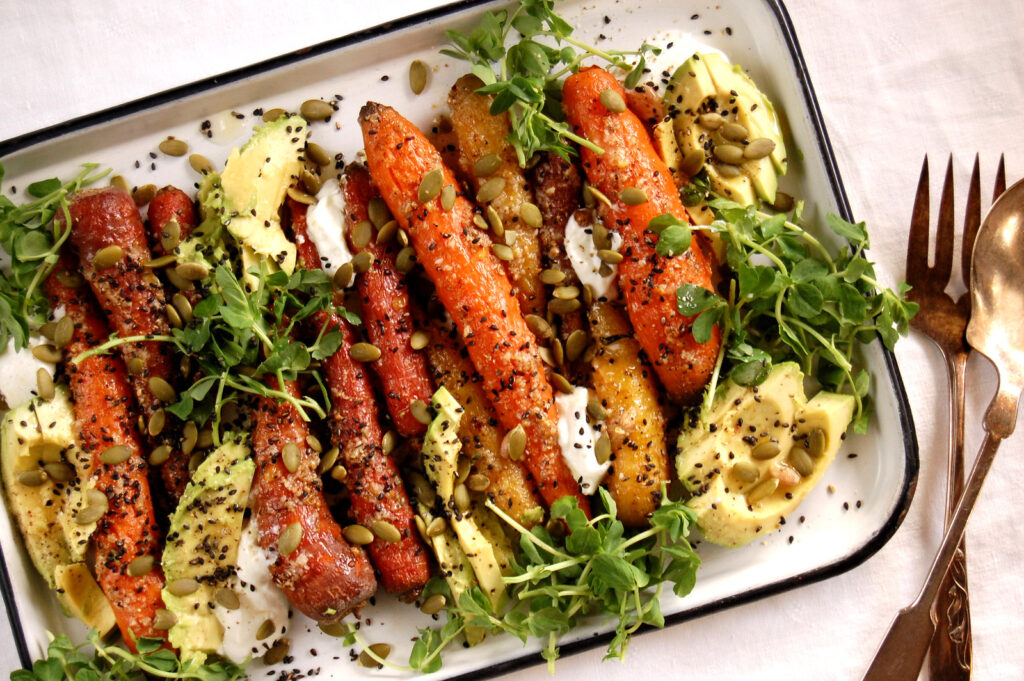 roasted carrot dish on sheet pan with fresh herb garnish