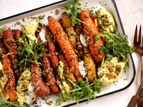roasted carrot dish on sheet pan with fresh herb garnish