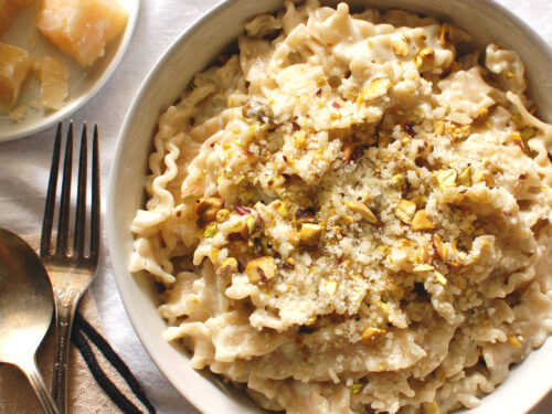 Creamy Gorgonzola pasta recipe with cooked pasta, sauce, toasted pistachios, and fresh black pepper in a white bowl.