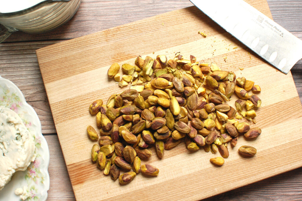 pistachios on cutting board about to be chopped for pasta dish.