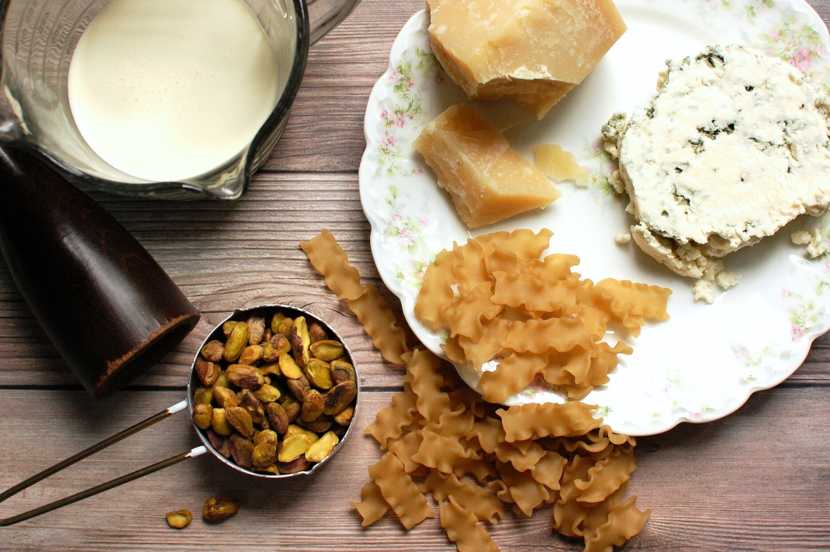 Ingredients for Gorgonzola pasta including Gorgonzola cheese, pasta, cream, butter, parmesan, nuts, and black pepper.