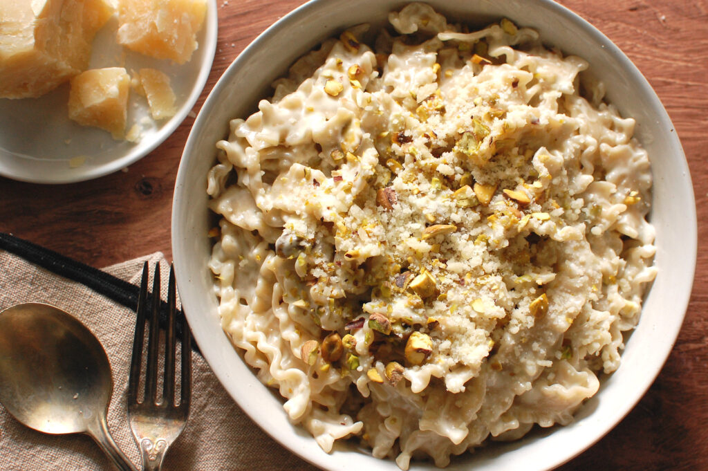 Creamy gorgonzola pasta in a wide bowl topped with toasted pistachios and Parmesan