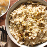 Creamy gorgonzola pasta in a wide bowl topped with toasted pistachios and Parmesan