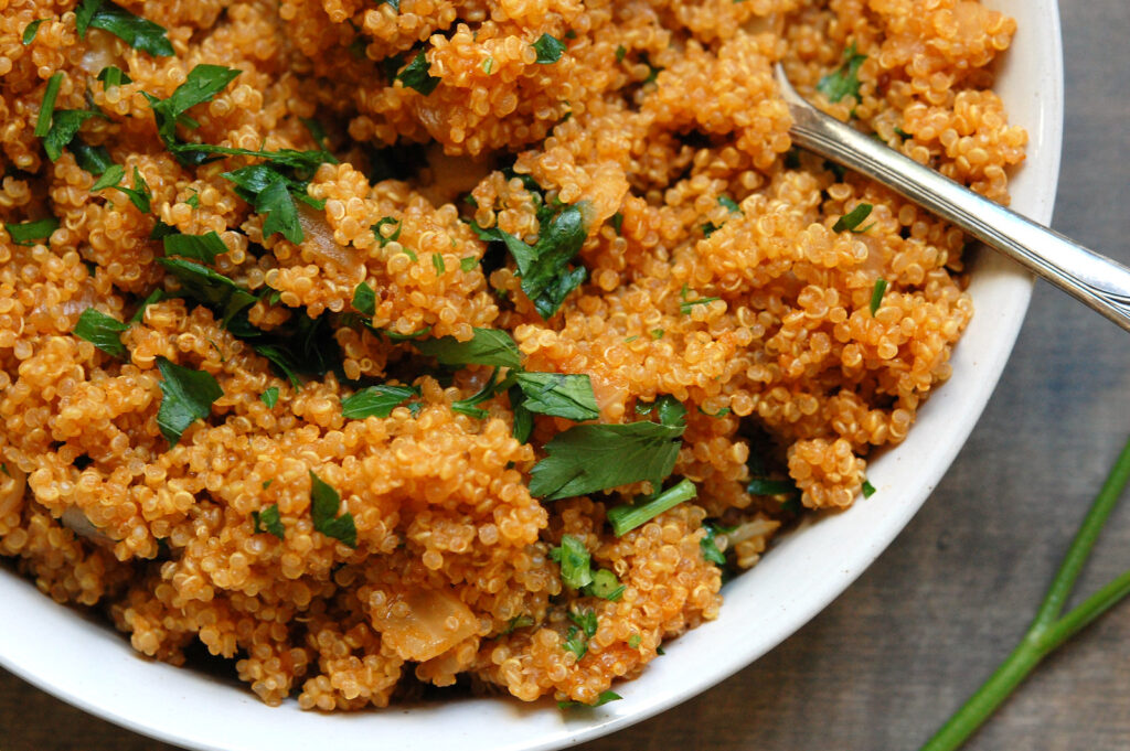 close-up of fluffy tender, flavorful quinoa with serving spoon to show texture and color