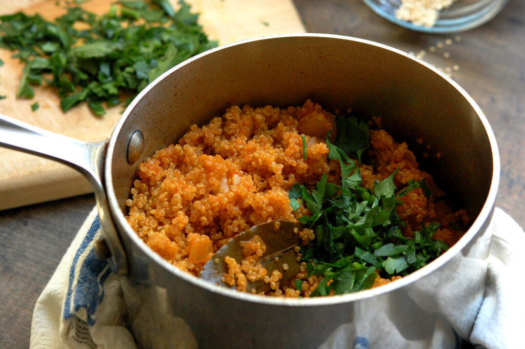 cooked quinoa in pot after being fluffed with a fork.